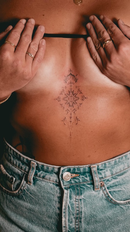 Ornamental sternum fine line tattoo